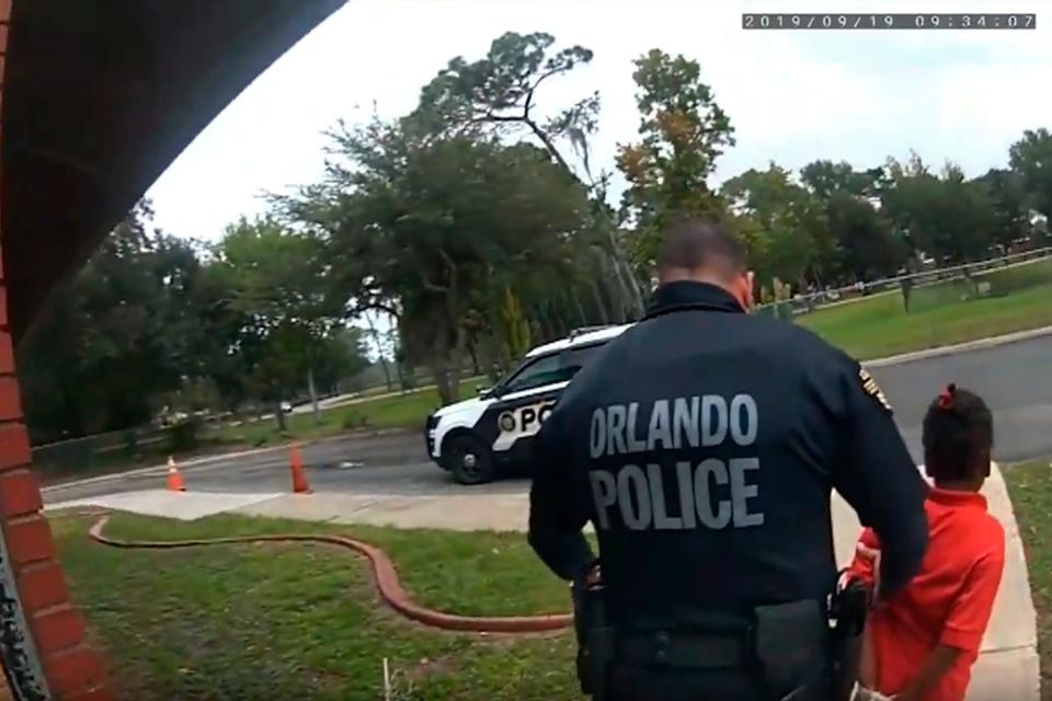 In this image taken from Sept. 19, 2019, Orlando Police Department body camera video footage, Orlando Police Officer Dennis Turner leads 6-year-old Kaia Rolle away after her arrest for kicking and punching staff members at the Lucious &amp; Emma Nixon Academy Charter School in Orlando, Fla. Turner was fired shortly after the arrest for not getting the approval of a watch commander to arrest someone younger than 12. (Orlando Police Department/Orlando Sentinel via AP)