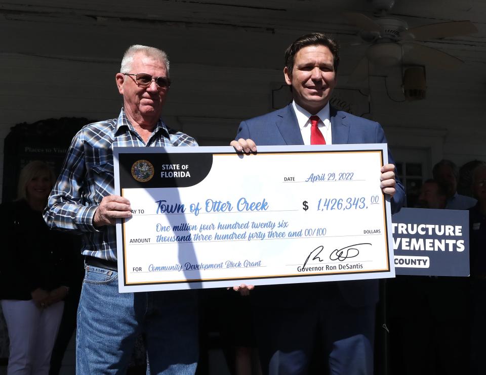 Gov. Ron DeSantis poses with Russell Meeks, the mayor of Otter Creek, for a check presentation of $1.4 million, which will pay for broadband internet service. DeSantis' press conference on Friday was held on the front porch of the Ivy House Restaurant in Williston.