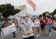 A woman wears a plastic bag decorated with stickers depicting Brazilian President Jair Bolsonaro as a virus, during a demonstration against Bolsonaro's handling of the coronavirus pandemic and economic policies protesters say harm the interests of the poor and working class, in Rio de Janeiro, Brazil, Saturday, June 19, 2021. Brazil is approaching an official COVID-19 death toll of 500,000 — second-highest in the world. (AP Photo/Bruna Prado)