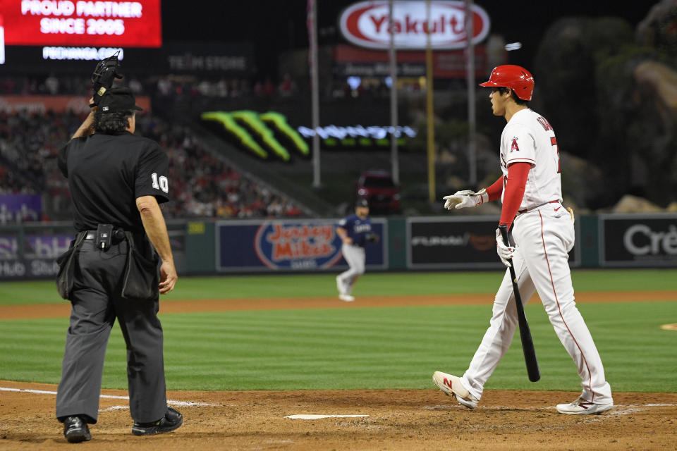 Los Angeles Angels' Shohei Ohtani, right, complains about a called strike three as home plate umpire Phil Cuzzi stands by during the fifth inning of a baseball game against the Seattle Mariners Saturday, June 10, 2023, in Anaheim, Calif. (AP Photo/Mark J. Terrill)