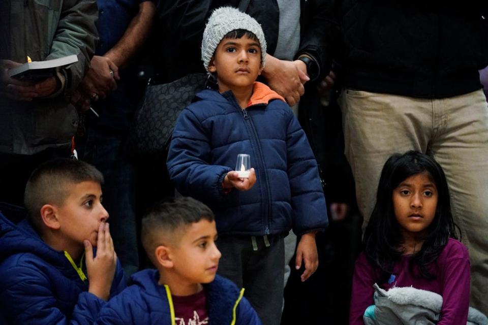 Mourners hold candles at a vigil for Wadea Al Fayoume at Prairie Activity and Recreation center in Plainfield, Ill., Tuesday, Oct. 17, 2023. An Illinois landlord accused of fatally stabbing the 6-year-old Muslim boy and seriously wounding his mother was charged with a hate crime after police and relatives said he singled out the victims because of their faith and as a response to the war between Israel and Hamas. (AP Photo/Nam Y. Huh)