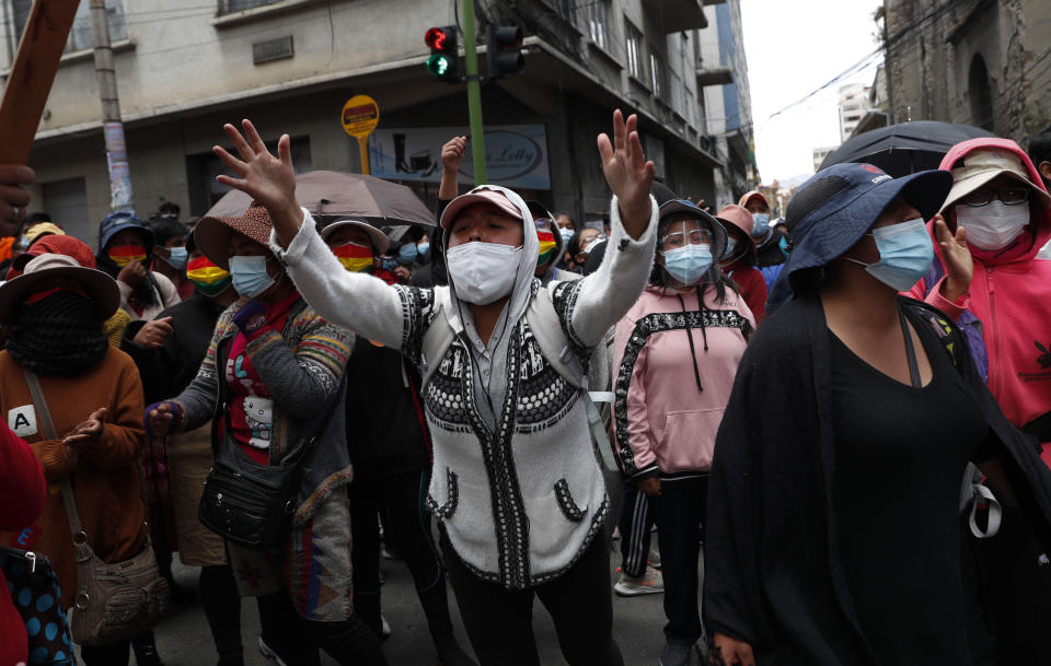 La gente grita durante una protesta en apoyo a los trabajadores de la salud en medio de la pandemia de COVID-19 en La Paz, Bolivia, el lunes 22 de febrero de 2021. Los trabajadores de la salud han convocado una huelga general para protestar contra una nueva ley sanitaria de emergencia que, entre otras cosas, permite la contratación de médicos extranjeros. (AP Foto/Juan Karita)