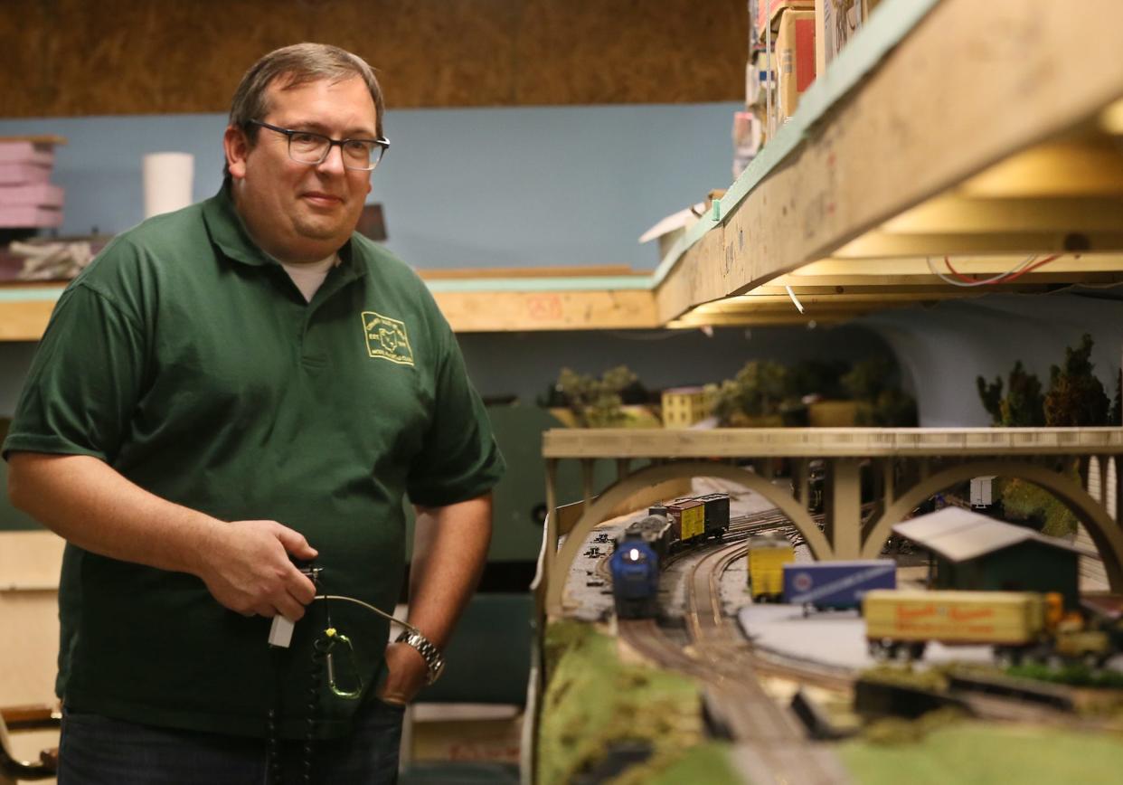 John Blystone, member of the Cuyahoga Valley Terminal Model Railroad Club, controls a train on the track. The club has built a historical model of the Valley Line set in the 1950s that includes real places in the Akron and Cleveland area.