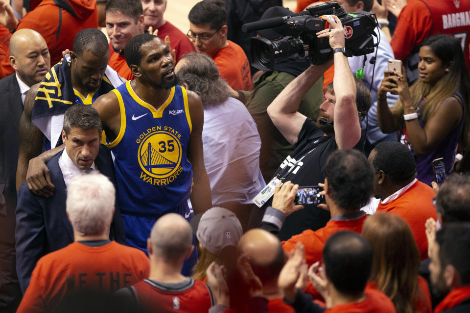 Golden State Warriors forward Kevin Durant glances up at the stands as he walks off the court after sustaining an injury during first half basketball action in Game 5 of the NBA Finals in Toronto, Monday, June 10, 2019. (Chris Young/The Canadian Press via AP)