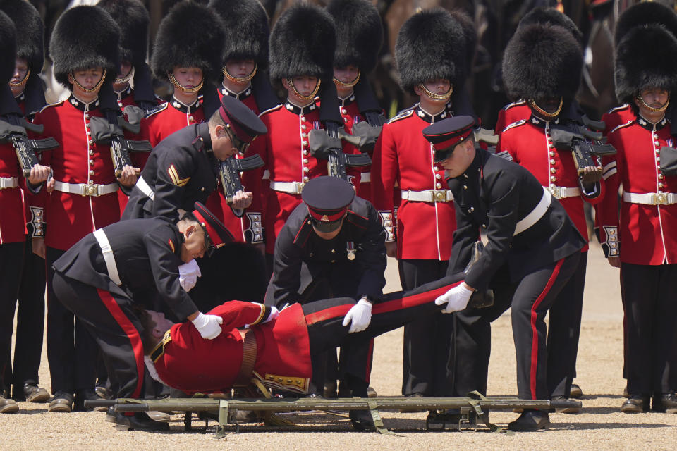 A soldier is carried out on a stretcher after a faint during the Colonel's Review, the final rehearsal of the Trooping the Colour, the King's annual birthday parade, at Horse Guards Parade in London, Saturday, June 10, 2023. (AP Photo/Alberto Pezzali)