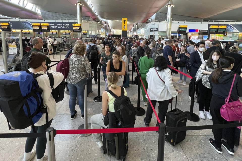 FILE - Travellers queue at security at Heathrow Airport in London, Wednesday, June 22, 2022. People face travelling disruption and long queues at airports amid the industry's ongoing staffing crisis. After two years of pandemic restrictions, travel demand is back with a vengeance but airlines and airports that slashed jobs during the depths of the COVID-19 crisis are struggling to keep up. With the busy summer tourism season underway in Europe, passengers are encountering chaotic scenes at airports, including lengthy delays, canceled flights and headaches over lost luggage. (AP Photo/Frank Augstein, File)