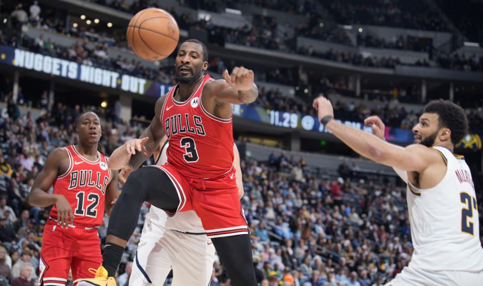 Chicago Bulls center Andre Drummond, left, loses control of the ball while driving to the basket past Denver Nuggets guard Jamal Murray in the second half of a preseason NBA basketball game Sunday, Oct. 15, 2023, in Denver. (AP Photo/David Zalubowski)