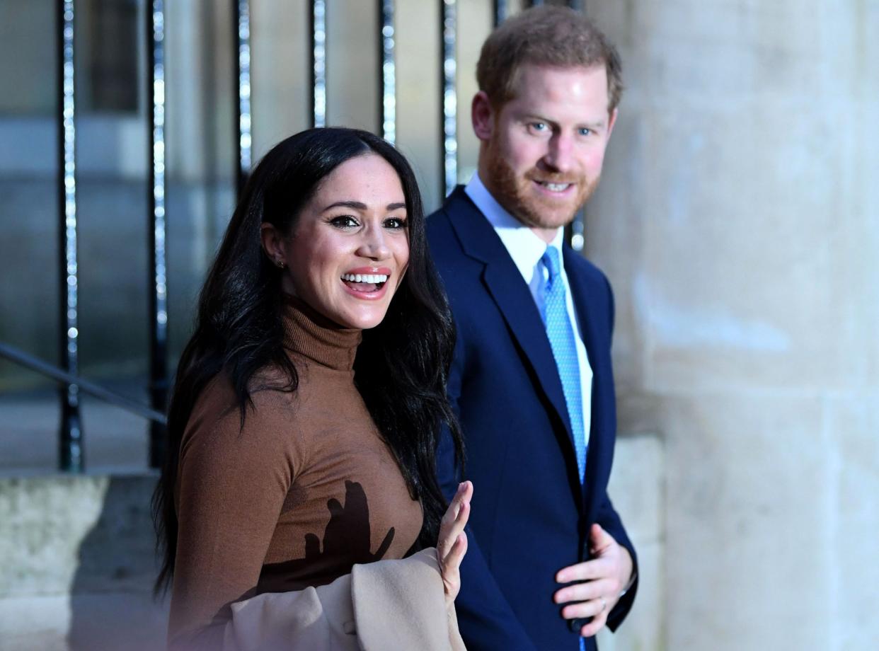 Prince Harry and Meghan react as they leave a visit: Getty