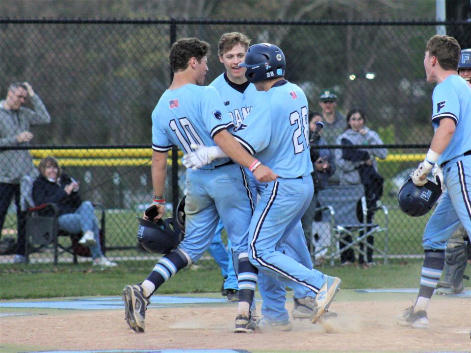 Franklin's Eisig Chin (28) is congratulated by teammates Jase Lyons (10) and Ben Jarosz after hitting a home run in a game against Taunton.