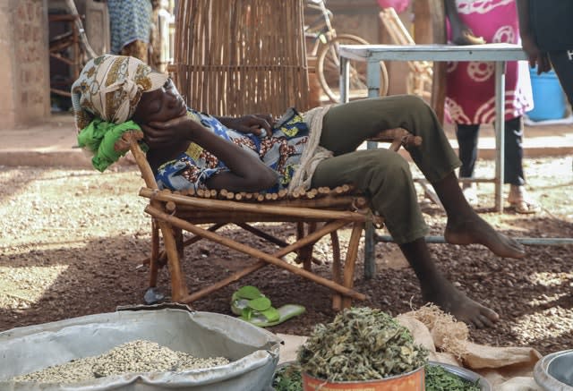 A child sleeps at a market stall selling food (Sam Mednick/AP)