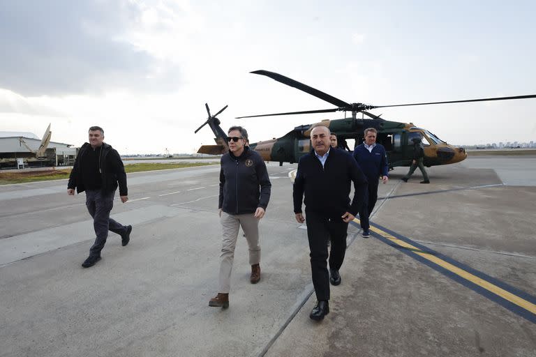El secretario de Estado de Estados Unidos Antony Blinken (en el centro y a la izquierda) y el ministro de Relaciones Exteriores de Turquía, Mevlut Cavusoglu (centro a la derecha) caminan tras bajar de un helicóptero en el que volaron sobre las áreas afectadas por el terremoto en la provincia turca de Hatay, el domingo 19 de febrero de 2023 en la base aérea de Incirlik cerca de Adana, Turquía. (Clodagh Kilcoyne/Foto de Pool vía AP)