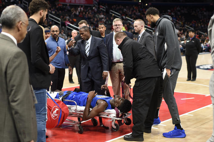 Orlando Magic forward Jonathan Isaac (1) lies on a stretcher after he sustained an injury during the first half of the team's NBA basketball game against the Washington Wizards, Wednesday, Jan. 1, 2020, in Washington. (AP Photo/Nick Wass)