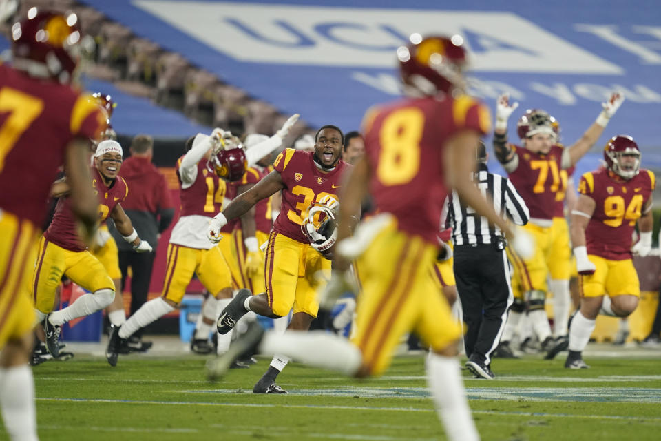 Southern California players run onto the field after winning an NCAA college football game against UCLA Saturday, Dec 12, 2020, in Pasadena, Calif. Southern (AP Photo/Ashley Landis)