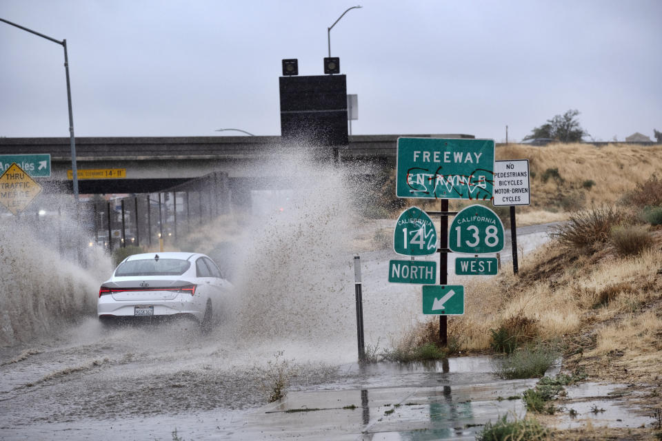 A vehicle drives through a flooded freeway entrance in Palmdale, Calif. as a tropical storm moves into the area on Sunday, Aug. 20, 2023. Forecasters said Tropical Storm Hilary was the first tropical storm to hit Southern California in 84 years, bringing the potential for flash floods, mudslides, isolated tornadoes, high winds and power outages. (AP Photo/Richard Vogel)