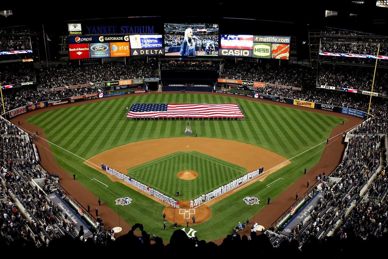 NEW YORK - OCTOBER 18: The likeness of Kristin Chenoweth is seen on the video screen as she performs the National Anthem and the Yankees and Texas Rangers stand on the foul lines prior to playing Game Three of the ALCS during the 2010 MLB Playoffs at Yankee Stadium on October 18, 2010 in New York, New York. (Photo by Andrew Burton/Getty Images)