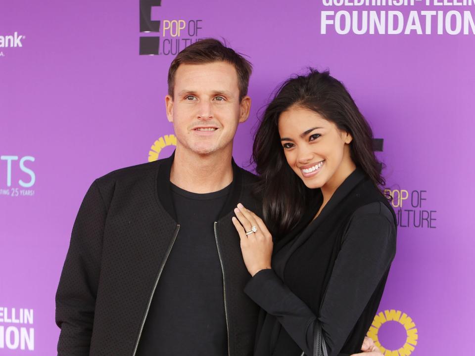 Rob Dyrdek and Bryiana Noelle pose against a purple background.