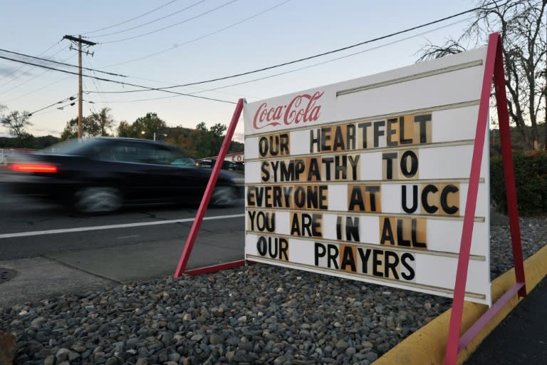 A car passes by a sign that shows support for victims of a mass shooting in Roseburg, Oregon, on October 2, 2015
