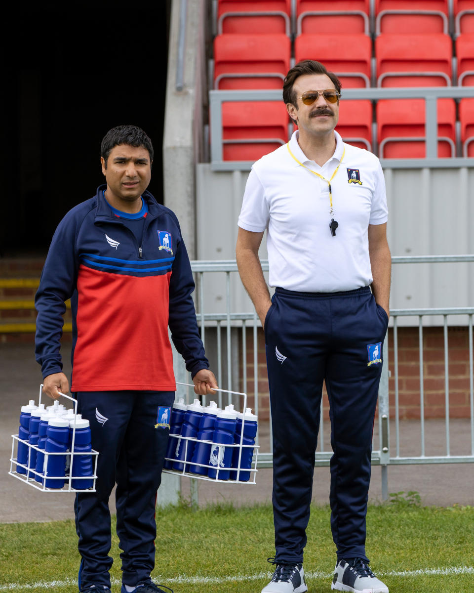 This image released by Apple TV Plus shows Nick Mohammed, left, and Jason Sudeikis, in “Ted Lasso,” premiering globally on Friday, August 14. (Apple TV Plus via AP)