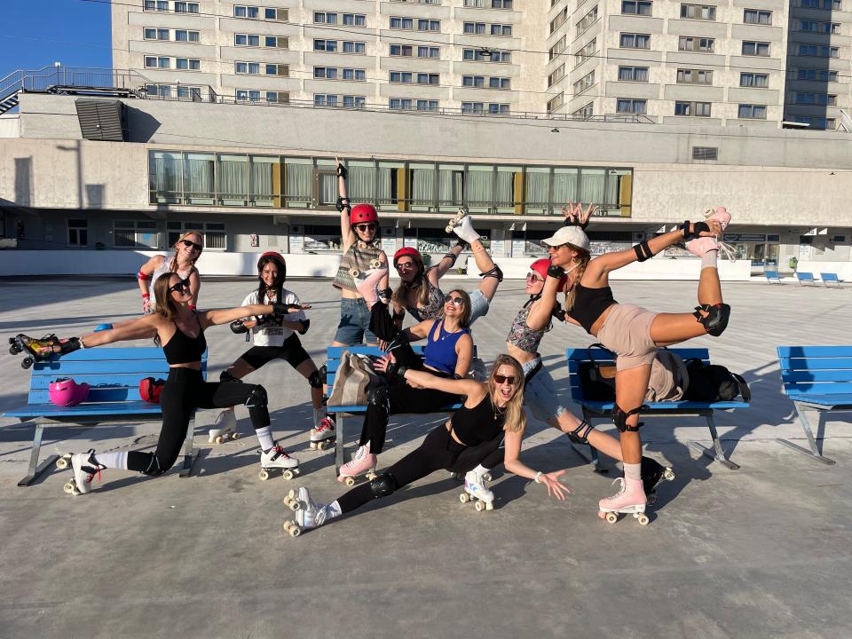 The author on a team outing with Fancypants yoga teacher team, all wearing roller skates and helmets by blue benches