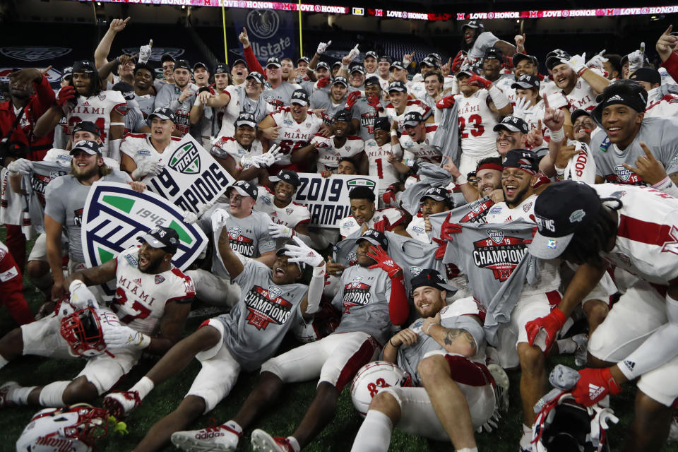 Members of the Miami of Ohio team pose on the field after the Mid-American Conference championship NCAA college football game against Central Michigan, Saturday, Dec. 7, 2019, in Detroit. (AP Photo/Carlos Osorio)