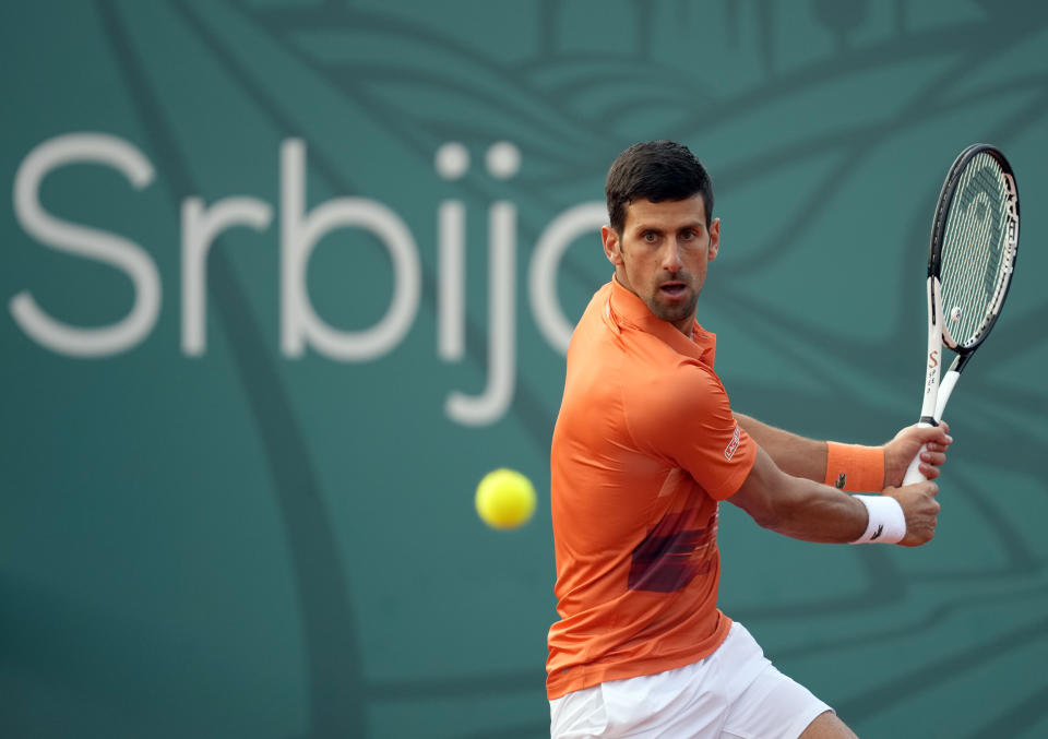 El serbio Novak Djokovic devuelve una pelota a su compatriota Laslo Djere durante su partido en el Abierto de Serbia en Belgrado, Serbia.  miércoles 20 de abril de 2022. Las autoridades del Abierto de Italia dijeron que Djokovic está  autorizado a jugar ese torneo.  (AP Foto/Darko Vojinovic)