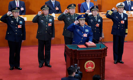 Newly elected vice chairman of the Central Military Commission Xu Qiliang (bottom) and (2nd row L to R) members of the Central Military Commission Zhang Shengmin and Li Zuocheng, vice chairman of the Central Military Commission Zhang Youxia, members of the Central Military Commission Wei Fenghe and Miao Hua, take an oath to the Constitution at the sixth plenary session of the National People's Congress (NPC) at the Great Hall of the People in Beijing, China March 18, 2018. REUTERS/Jason Lee/Files