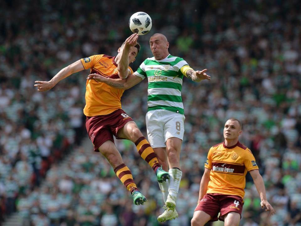 Scott Brown attempts to head clear a Motherwell cross under pressure from Carl McHugh (Getty)