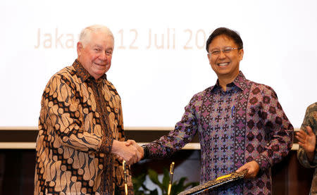 Freeport-McMoRan Chief Executive Officer Richard Adkerson (L), and PT Inalum Chief Executive Budi Gunadi Sadikin shake hands after signing an initial agreement for the state-owned mining company Inalum to take a controlling stake in Freeport's local unit, in Jakarta, Indonesia, July 12, 2018. REUTERS/Darren Whiteside