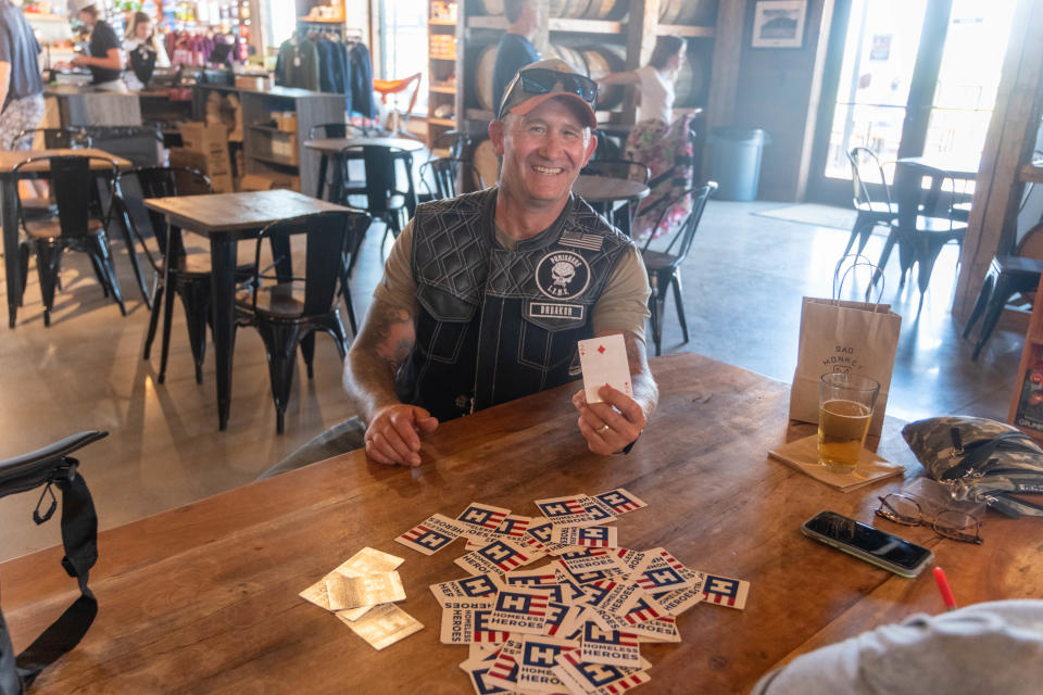 A participant holds up his card Saturday at Sad Monkey Mercantile near Palo Duro Canyon during the sixth annual Homeless Heroes Bike Run.