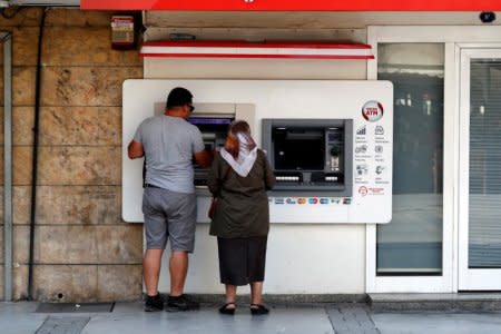 People withdraw money from a bank ATM in Izmir, Turkey August 18, 2018. REUTERS/Osman Orsal