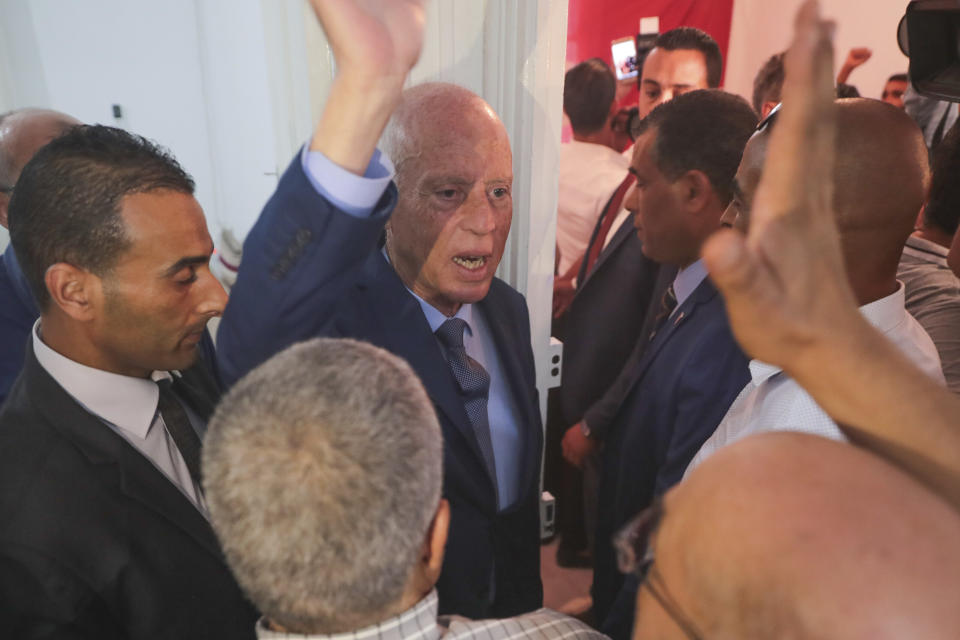 Tunisian independent law professor Kais Saied waves to his supporters after advancing to the second round in the country's presidential elections, in his office in Tunis, Tunisia, Tuesday, Sept.17, 2019. Tunisia's electoral authority says that jailed media magnate Nabil Karoui and independent law professor Kais Saied are advancing to the country's presidential election runoff. (AP Photo/Mosa'ab Elshamy)