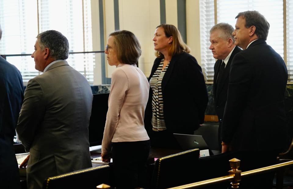 Katherine Snyder, wearing the light pink sweater, and her husband John, at right, stand as jurors enter the courtroom of Hamilton County Common Pleas Judge Wende Cross for the start of their murder trial on Friday.