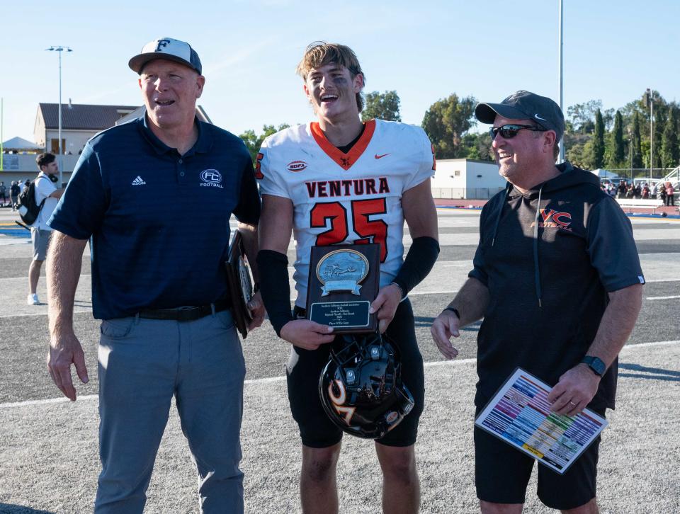 Ventura College safety Zane Carter (middle) is awarded the Defensive Player of the Game trophy after the Pirates' win at Fullerton College Saturday in the Southern California semifinals.