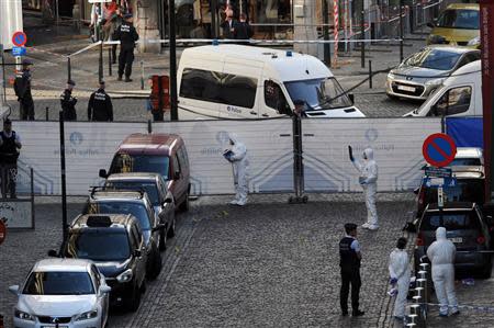 Police personnel are seen at the site of a shooting in Brussels