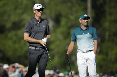 Justin Rose of England (L) watches his tee shot on the 12th with Sergio Garcia of Spain in final round play during the 2017 Masters golf tournament at Augusta National Golf Club in Augusta, Georgia, U.S., April 9, 2017. REUTERS/Mike Segar