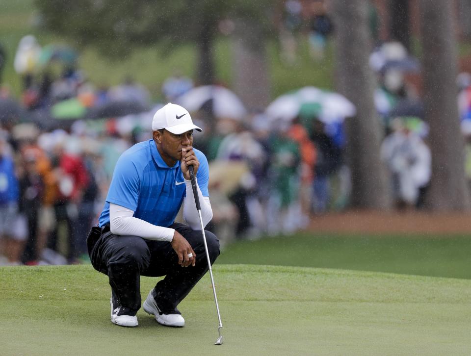 Tiger Woods waits to putt in the rain on the seventh hole during the third round at the Masters golf tournament (AP Photo/David J. Phillip)