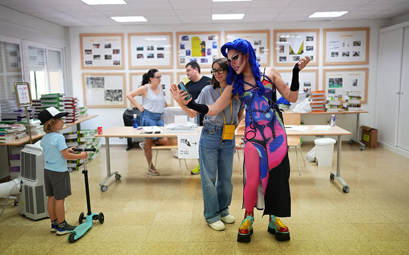 A voter poses for a selfie with Onyx, right, a drag queen doing election work at a polling station.