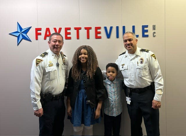 Fayetteville Police Chief Kemberle Braden, left, and Assistant Chief Robert Ramirez take a photo with Louisiana teen Rosalyn Baldwin and her brother Phillip on Friday, Jan. 26, 2024. Rosalyn and her family are on a mission to visit all 50 states to hug police officers.