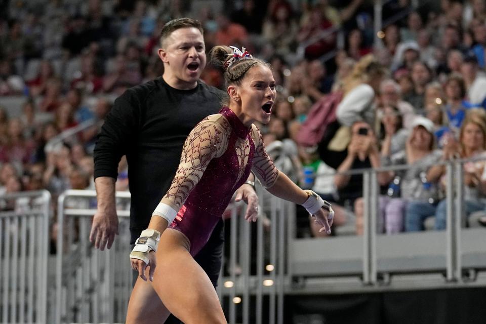 Oklahoma's Jordan Bowers and associate head coach Lou Ball, rear, celebrate after Bowers competed on the uneven bars during the final of the NCAA women's gymnastics championships Saturday, April 15, 2023, in Fort Worth, Texas. (AP Photo/Tony Gutierrez)