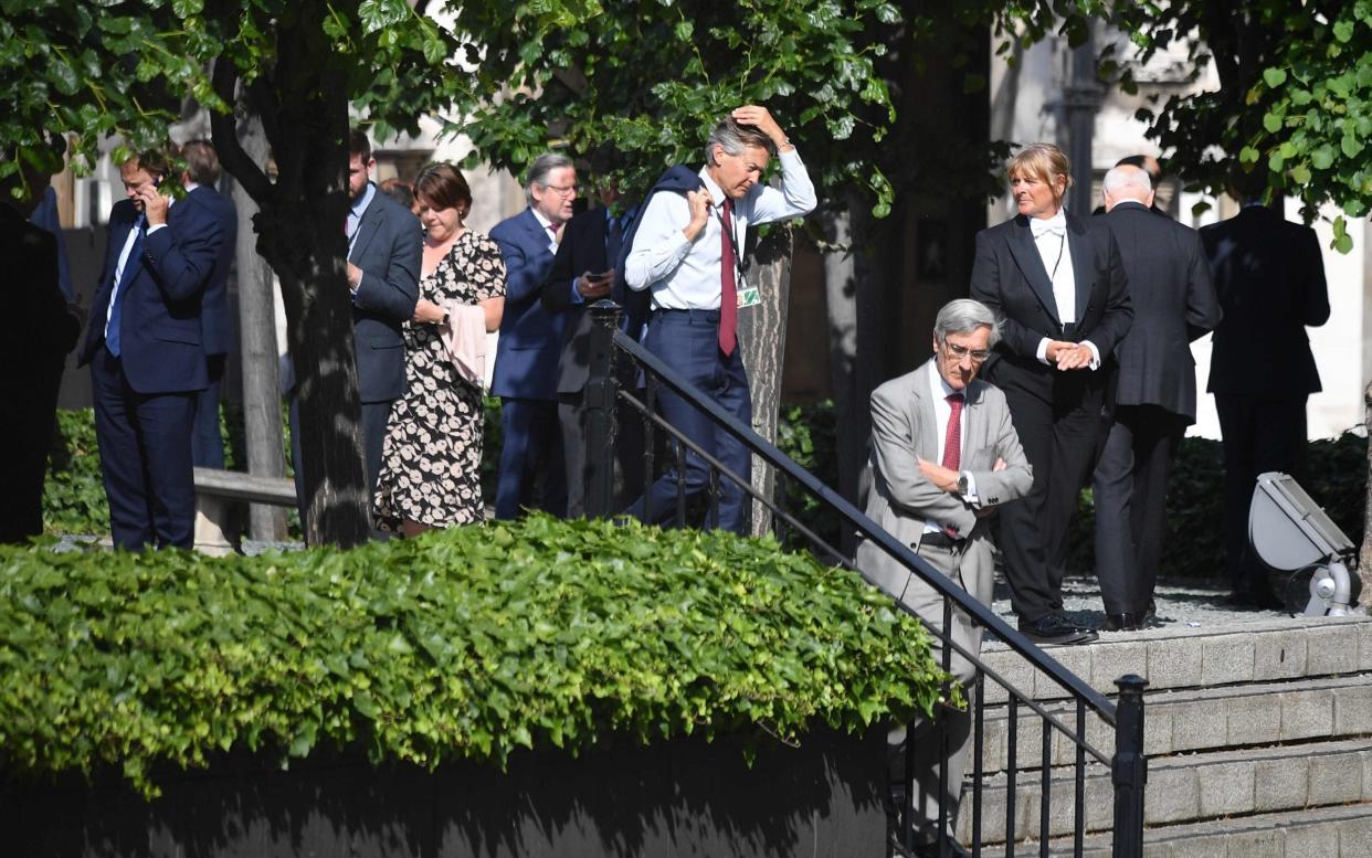 Waiting game: MPs stand in the sunshine before casting their votes - Justin Tallis/AFP