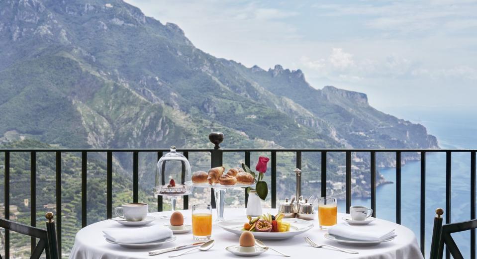 a table with food and drinks on it with mountains in the background