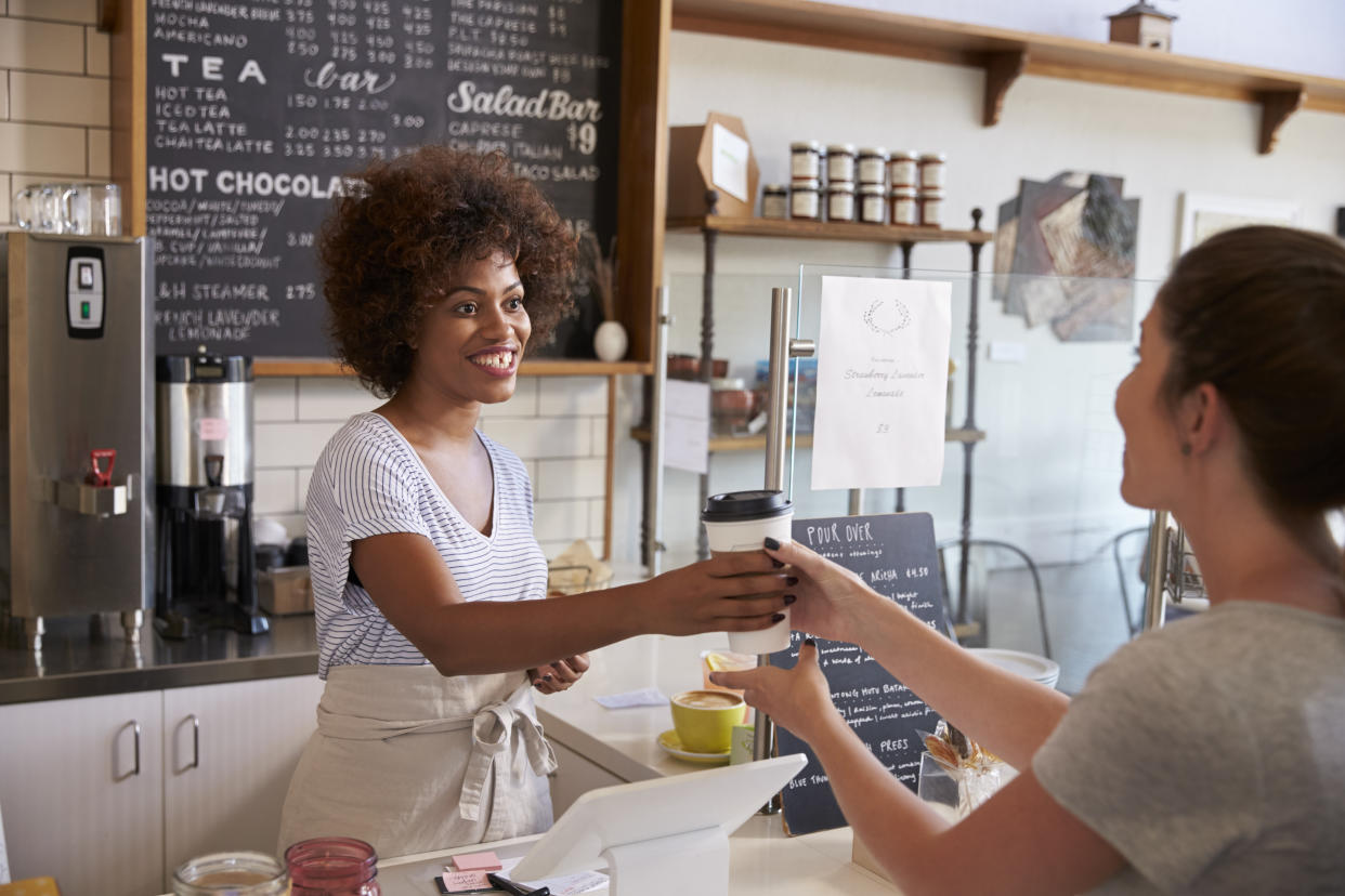 Waitress serving customer over the counter at a coffee shop