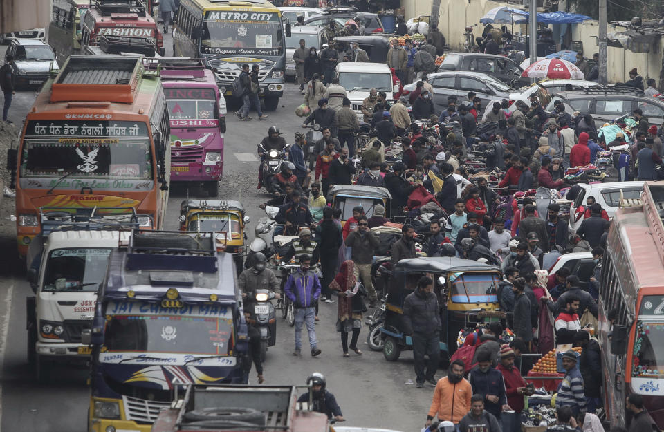 Indians,some of them, wearing face masks as a precautionary measure against the coronavirus crowd a Sunday market in Jammu, India, Sunday, Jan.3, 2021.(AP Photo/Channi Anand)