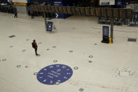 Social distancing guidelines on the floor by train departure information screens to help stop the spread of coronavirus in Waterloo station, London, Thursday, June 4, 2020. Waterloo station, which is wide recognised as the busiest train station in Britain, is still much quieter than normal as most commuters are working from home and not commuting into central London offices. (AP Photo/Matt Dunham)