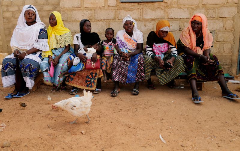 Women who fled from attacks of armed militants in Sahel region of Soum sit at a courtyard of the house in an informal camp for displaced people on the outskirts of Ouagadougou,