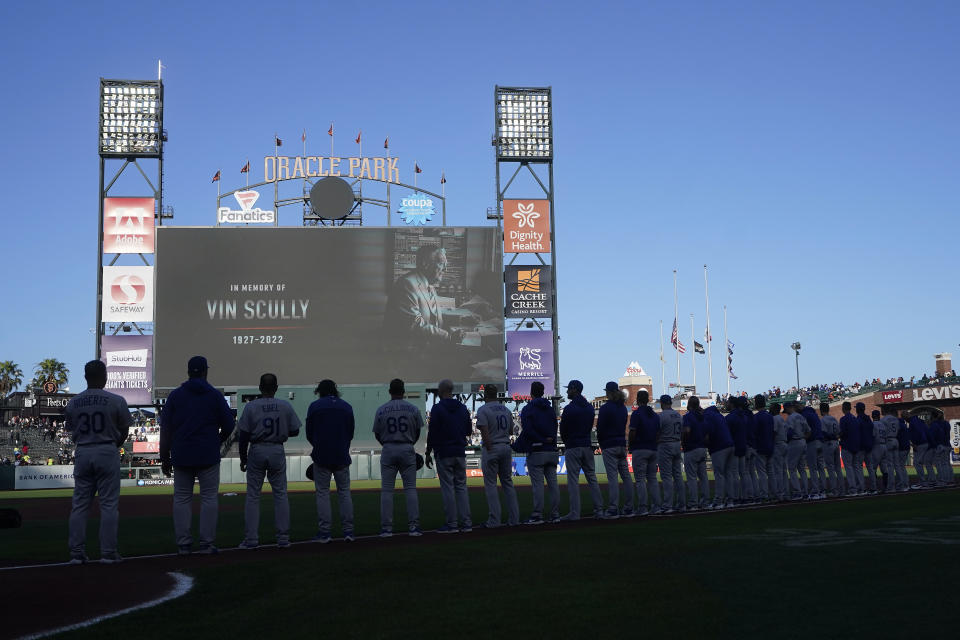 A tribute to broadcaster Vin Scully is shown on a video board at Oracle Park above Los Angeles Dodgers players and coaches before a baseball game between the San Francisco Giants and the Dodgers in San Francisco, Wednesday, Aug. 3, 2022. (AP Photo/Jeff Chiu)