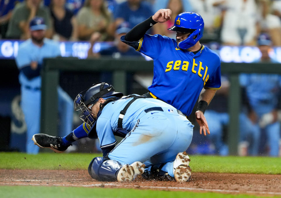 Seattle Mariners' AJ Pollock is tagged out at home by Toronto Blue Jays catcher Danny Jansen during the seventh inning of a baseball game, Friday, July 21, 2023, in Seattle. (AP Photo/Lindsey Wasson)