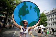 A protester carries a sign depicting the earth during the Peoples Climate March near the White House in Washington, U.S., April 29, 2017. REUTERS/Joshua Roberts