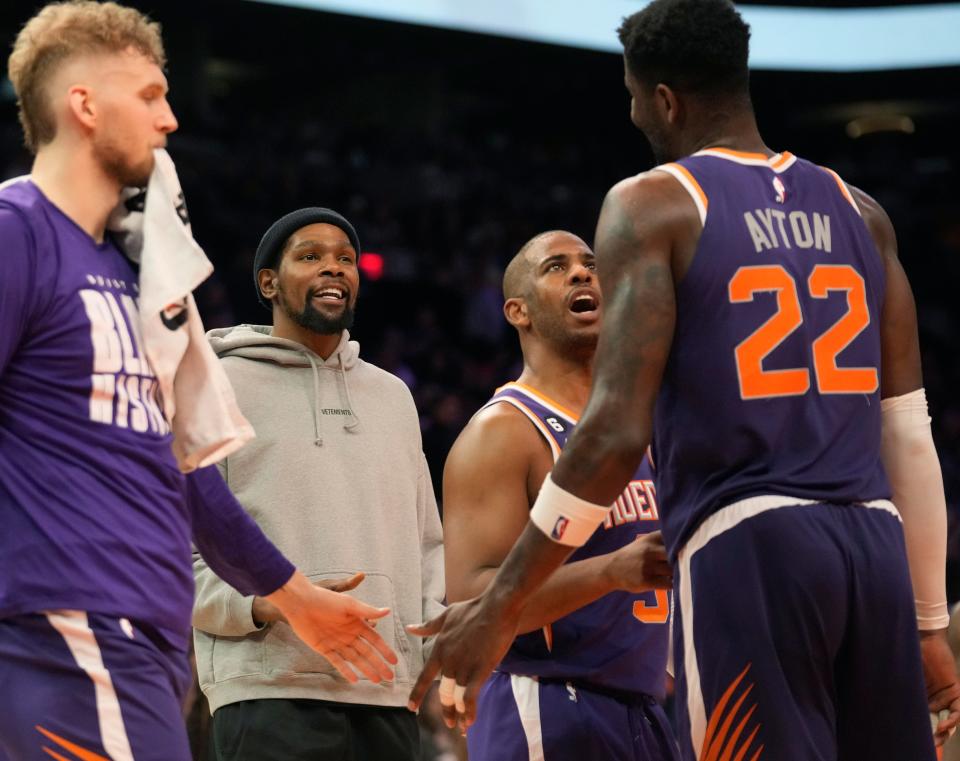 Phoenix Suns forward Kevin Durant (center) and guard Chris Paul (3) talk with Phoenix Suns center Deandre Ayton (22) during the fourth quarter against the Sacramento Kings at Footprint Center in Phoenix on Feb. 14, 2023.