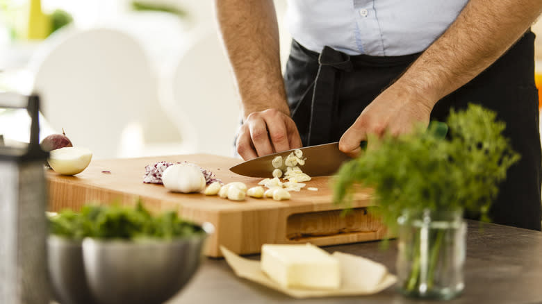 Chef slicing fresh garlic